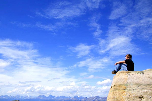 Boy on top of mountain enjoying the view (photo: DesignPics Inc.)